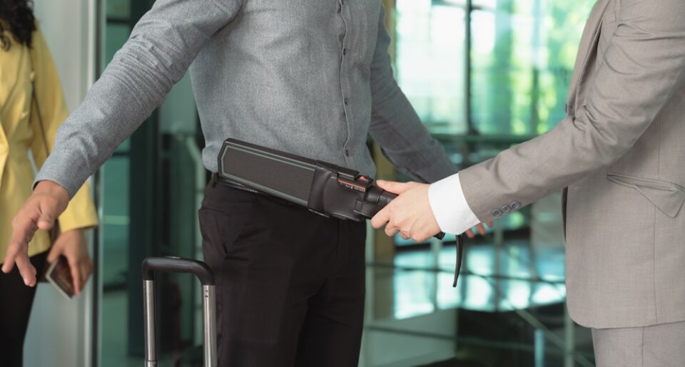 A man being scanned by airport security.