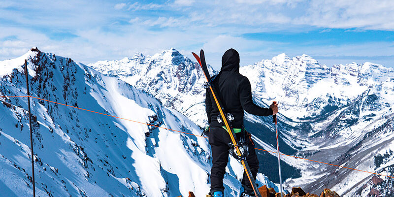 Man on skis looking over snowy mountain in Europe