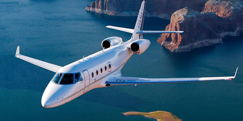 Gulfstream G150 Midsize Jet flying over water and mountains