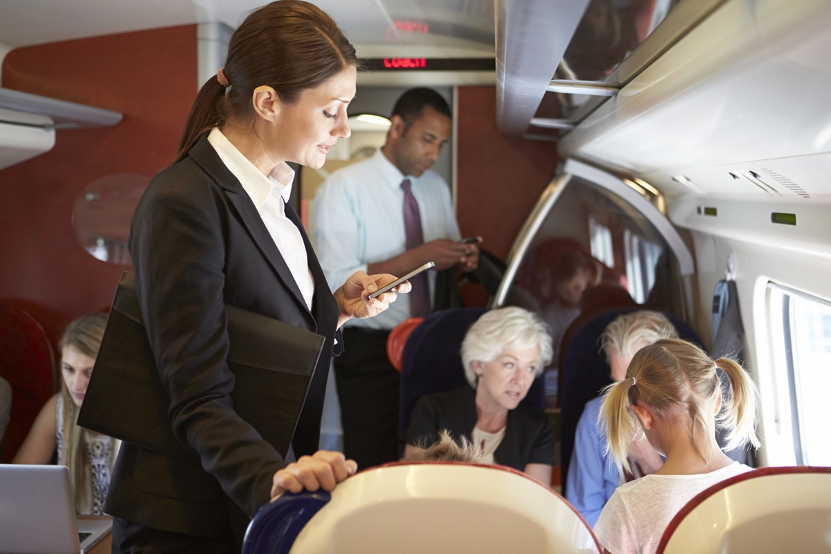 A steward and stewardess with a family on a plane.