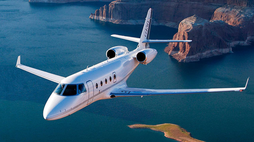 Gulfstream G150 Midsize Jet flying over water and mountains